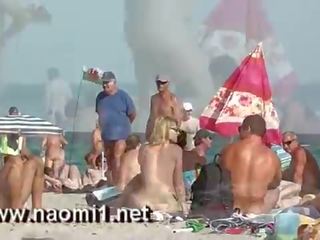 Naomi1 stimulim me dorë një i ri djalosh në një publike plazh